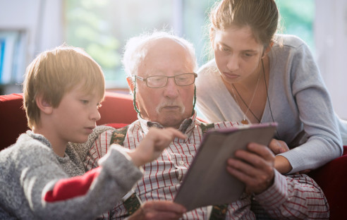 Opa mit seinen Enkeln am Tablet