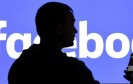 Mann steht vor Facebook-Logo