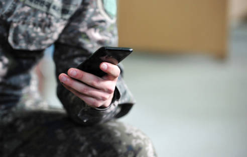 Soldat mit Smartphone in der Hand