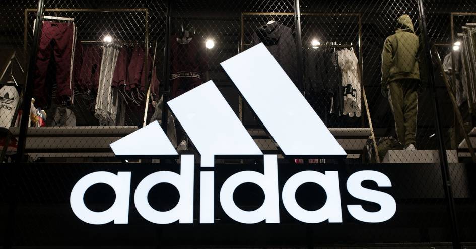 Adidas Logo vor Produkten im Hintergrund