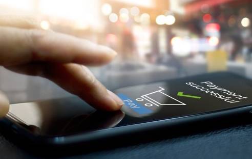 Hand vor Smartphone-Screen, der Zahlungsbestätigung anzeigt