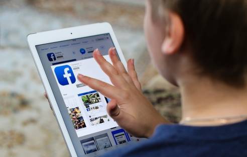 Junge nutzt Facebook auf dem Tablet