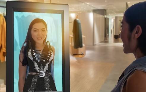 Frau vor Bildschirm mit virtueller Mode