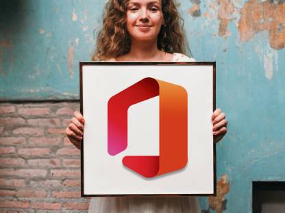 Eine junge Frau steht vor einer etwas verwitterten Mauer; in ihren Händen hält sie ein Bild mit dem Logo von Microsoft Office
