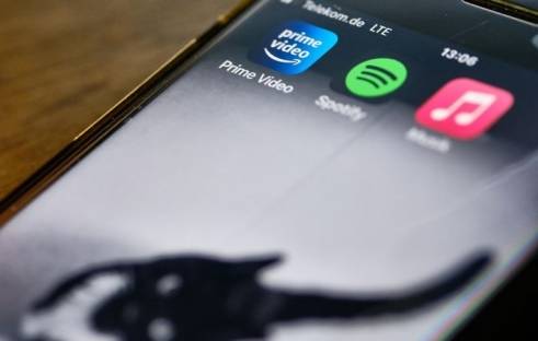 Die Apps der Streaming-Anbieter Amazon Prime Video, Spotify und Apple Music sind auf dem Display eines iPhones zu sehen.