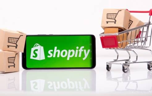 Smarphone mit kleinem Einkaufswagen und Shopify-App