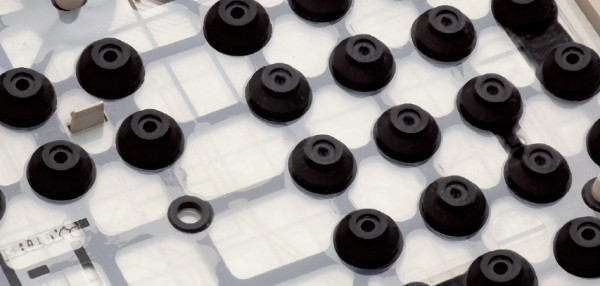 Rubberdome-Tastatur: Auf der oberen Plastikfolie sind Gummikappen angebracht. Werden Sie heruntergedrückt, fließt Strom und die Taste wird ausgelöst.