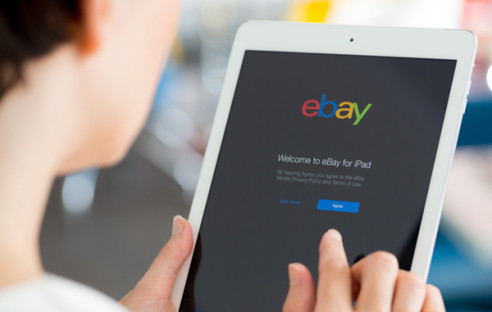 Frau surft mit Tablet auf eBay
