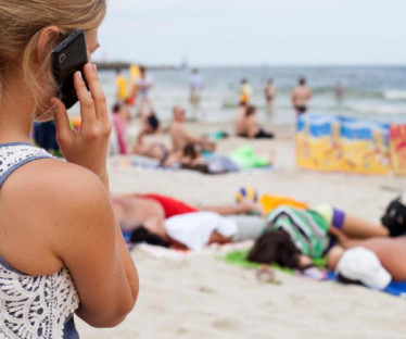 Frau telefoniert am Strand